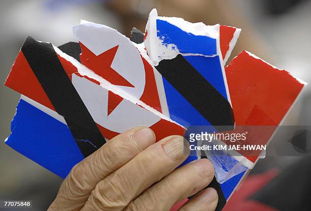 South Korean protester holds up the pieces of a North Korean flag placard that was torn up during an anti-North Korea rally in Seoul, 28 September...