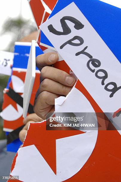 South Korean protester holds up the pieces of a North Korean flag placard that was torn up during an anti-North Korea rally in Seoul, 28 September...