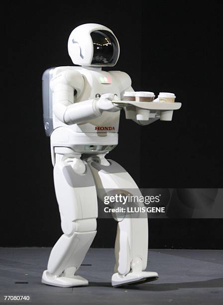 Honda's second version of the humanoid robot Asimo walks carrying a tray with drinks, 28 September 2007, in Barcelona during its first appearance in...