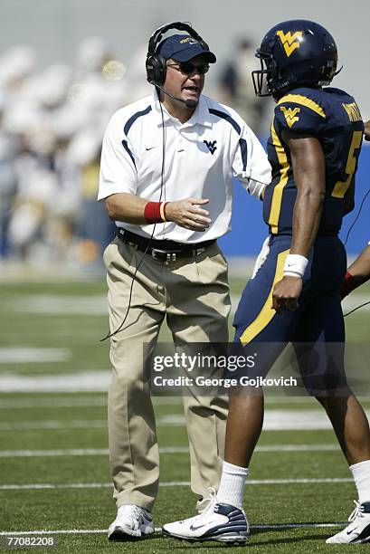 Head coach Rich Rodriguez of the West Virginia University Mountaineers talks with quarterback Patrick White during a college football game against...