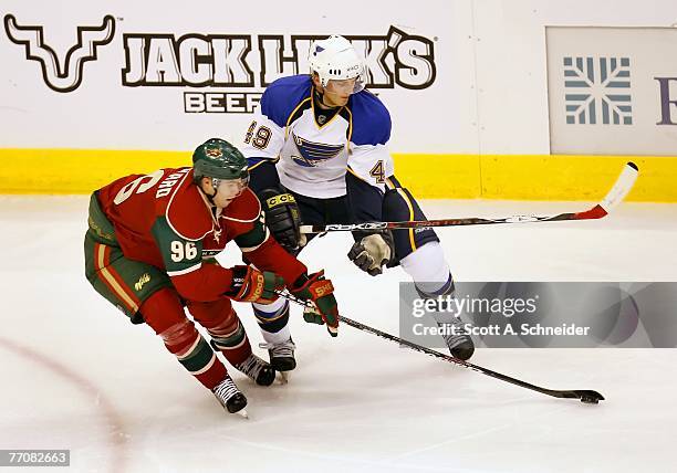 Pierre-Marc Bouchard of the Minnesota Wild takes the puck from Steve Wagner of the St. Louis Blues during their preseason game September 26, 2007 at...