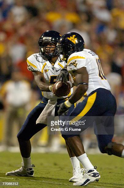 Patrick White of the West Virginia Mountaineers hands the ball to Steve Slaton against the Maryland Terrapins on September 13, 2007 at Byrd Stadium...