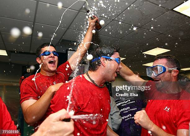 Josh Beckett of the Boston Red Sox is sprayed by teammates after they defeated the Minnesota Twins 5-2 and the New York Yankees lost to the Baltimore...