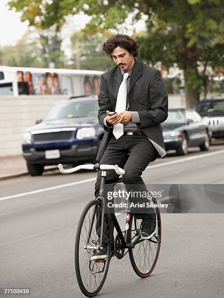 hispanic businessman riding bicycle - hands free cycling - fotografias e filmes do acervo