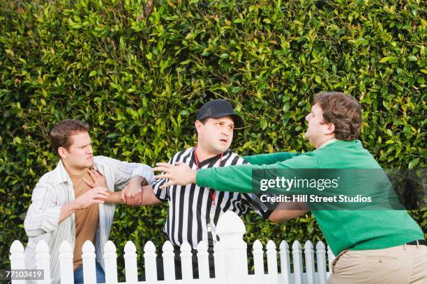 hispanic referee between arguing neighbors - fighting photos et images de collection