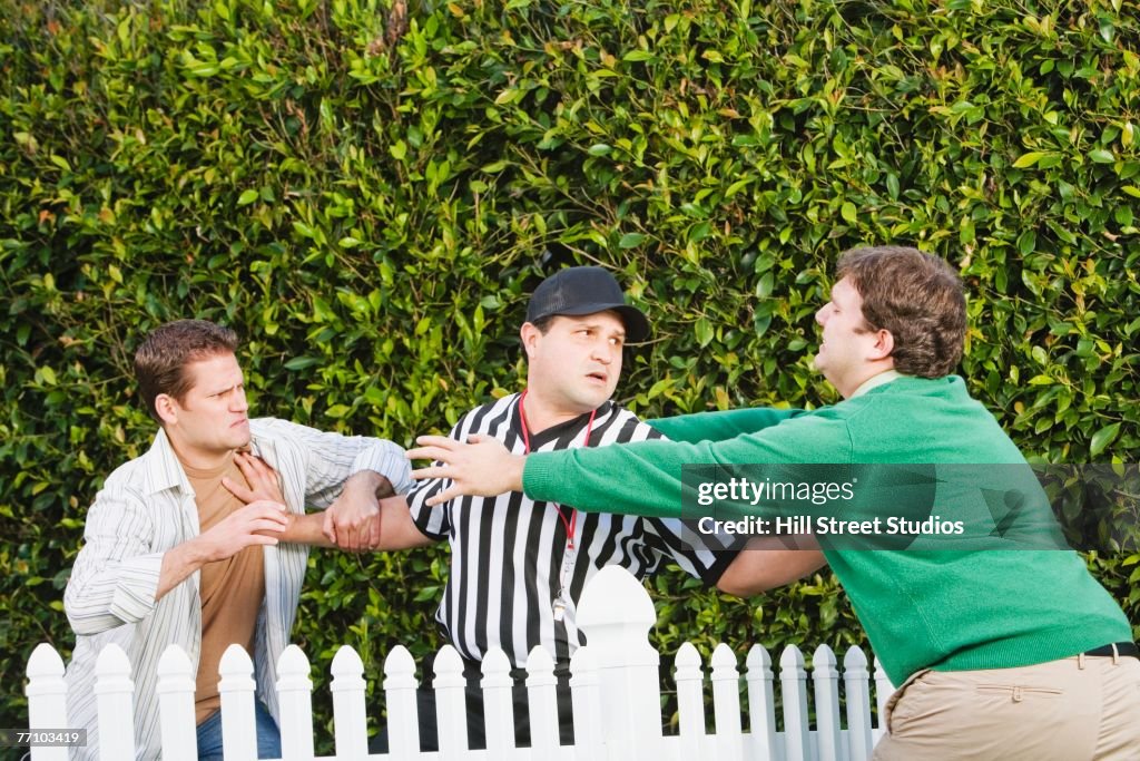 Hispanic referee between arguing neighbors