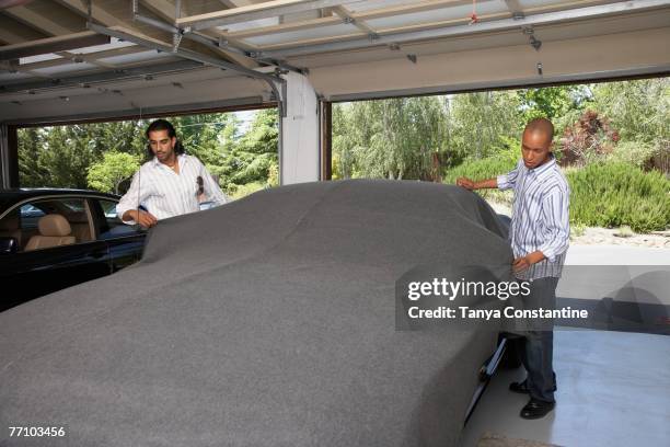 multi-ethnic men covering car - car cover garage stock pictures, royalty-free photos & images