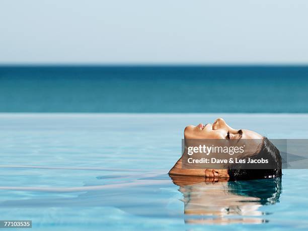 hispanic woman in swimming pool - reflet eau photos et images de collection