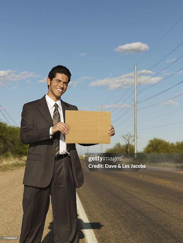 Hispanic businessman holding blank sign