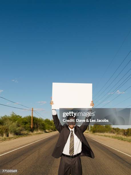 hispanic businessman holding blank sign - hitchhike stock-fotos und bilder