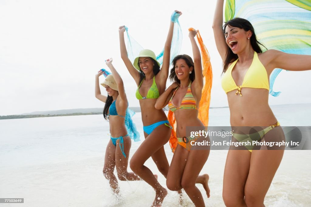 South American women jumping on beach