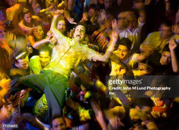 hispanic man crowd surfing at nightclub - crowdsurfing stockfoto's en -beelden
