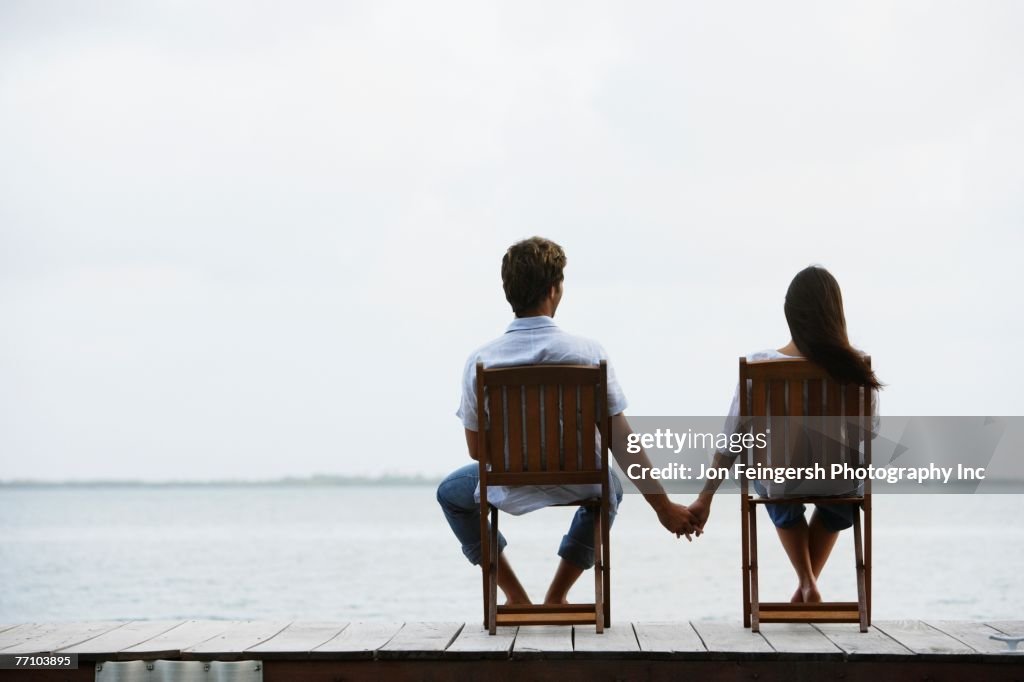 South American couple holding hands on dock
