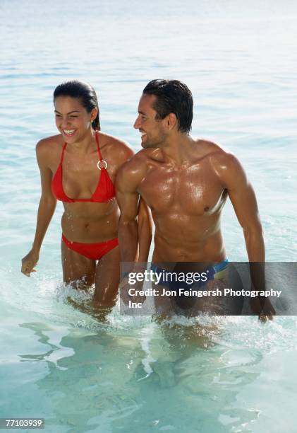 south american couple walking in water - man and woman holding hands profile stockfoto's en -beelden