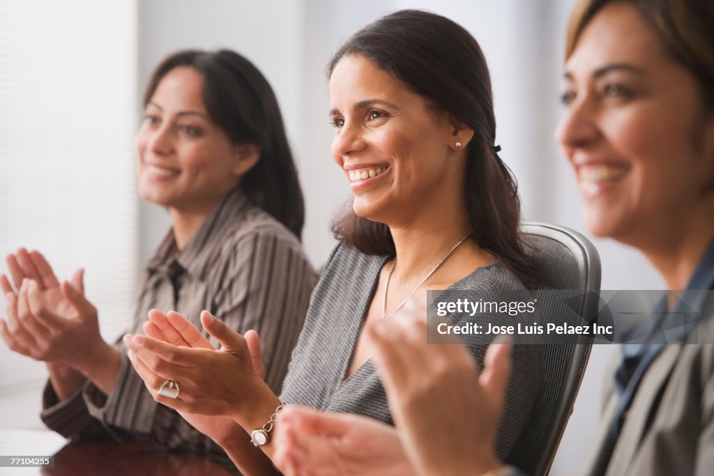 Hispanic businesswomen clapping