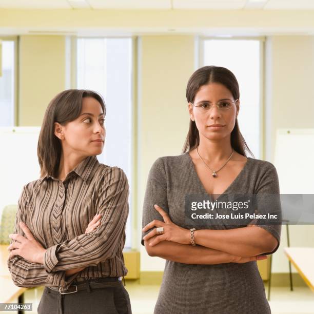 hispanic businesswomen with arms crossed - suspicion stock pictures, royalty-free photos & images