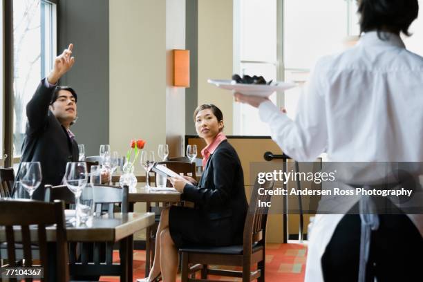 asian man signaling restaurant server - serveur restaurant stock pictures, royalty-free photos & images