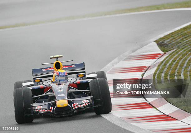 Australian driver Mark Webber of Red Bull negotiates a corner under the rain during the qualifying session for the Formula One Japanese Grand Prix in...