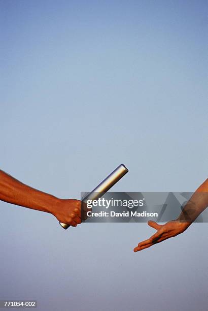 hands of relay runners passing baton - estafette stockfoto's en -beelden