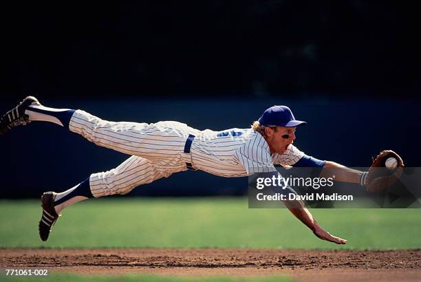 baseball player diving to catch ball - sich zu boden werfen stock-fotos und bilder