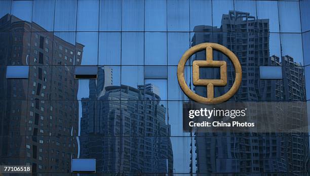 Buildings under construction are reflected on glass at the People's Bank of China office building on September 29, 2007 in Chongqing, China. The...