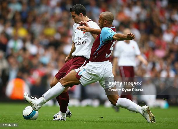 Robin Van Persie of Arsenal is tackled by Anton Ferdinand of West Ham during the Barclays Premier League match between West Ham United and Arsenal at...
