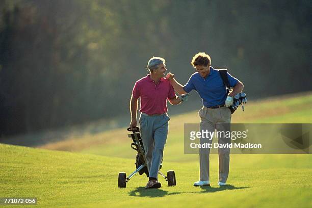 golf, players walking on fairway - golfer walking stock pictures, royalty-free photos & images