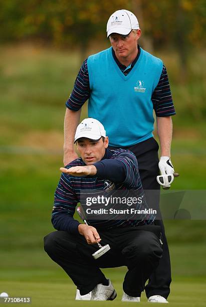 Simon Dyson and Oliver Wilson of The Great Britain and Ireland Team ponder a putt on the 15th hole during the third day afternoon foursomes at the...