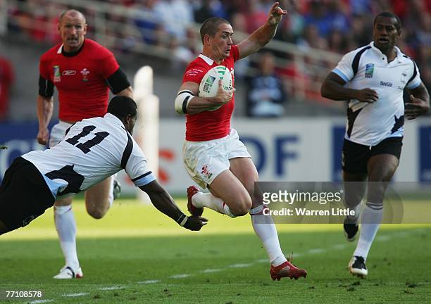 Shane Williams of Wales goes past the tackle from Isoa Neivua of Fiji during the Rugby World Cup 2007 Pool B match between Wales and Fiji at the...