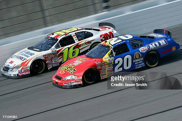Greg Biffle, driver of the 3M Ford, races side by each against Denny Hamlin, driver of the Slim Jim/Act II Chevrolet, during the NASCAR Busch Series...