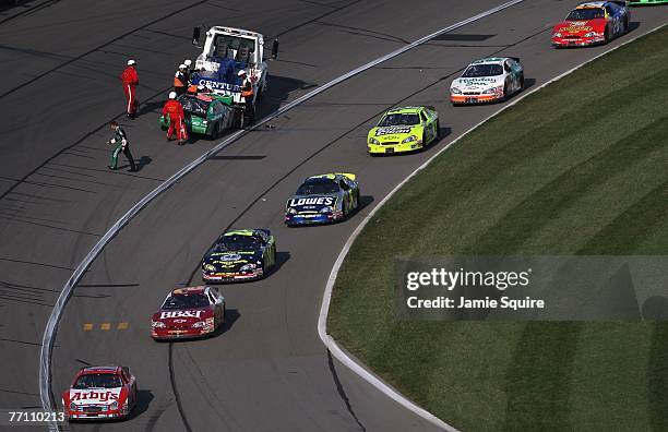 Cars drive under caution as the car of Carl Edwards, driver of the Scotts Ford is towed off the track during the NASCAR Busch Series Yellow...