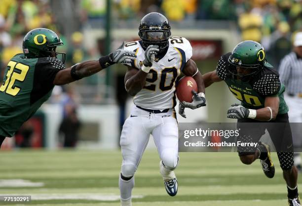 Justin Forsett of the California Golden Bears runs the ball against Jarius Byrd and Matthew Harper of the Oregon Ducks at Autzen Stadium on September...