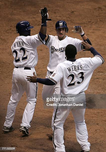 Ryan Braun of the Milwaukee Brewers is greeted by teammates Tony Gwynn and Rickie Weeks after scoring the winning run in the 11th inning against the...