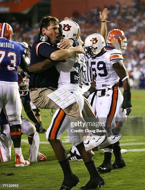 Defensive coordinator Will Muschamp of the Auburn Tigers jumps into the arms of defensive back Patrick Lee after Lee helped cause a fumble late in...