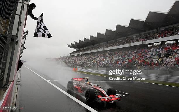 Lewis Hamilton of Great Britain and McLaren Mercedes crosses the finish line to win the Japanese Formula One Grand Prix at the Fuji Speedway on...