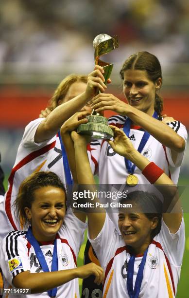 Fatmire Bajramaj, Sandra Smisek, and Kerstin Garefrekes of Germany celebrate with the trophy at the end of the Women's World Cup 2007 Final between...