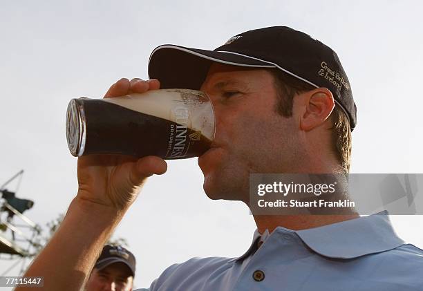 Bradley Dredge of The Great Britain and Ireland Team drinks a pint of Guinness after winning his match during the final day singles at the Seve...
