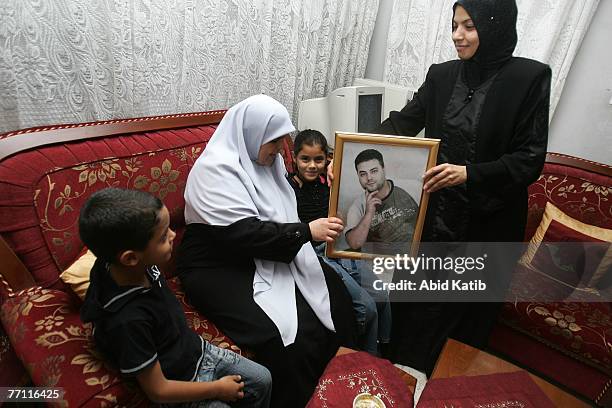 Oula Adnan Hasanen holds a picture of her husband Abdelhadi Hasan Hasanen who has spent six years of a 12-year sentence in an Israeli prison, as she...