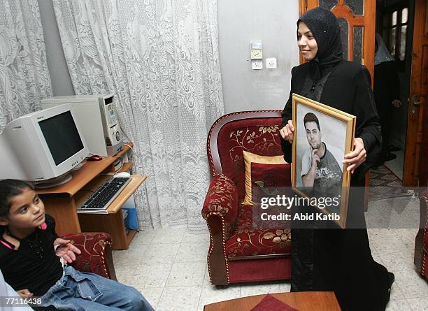 Oula Adnan Hasanen holds a picture of her husband Abdelhadi Hasan Hasanen who has spent six years of a 12-year sentence in an Israeli prison, as her...