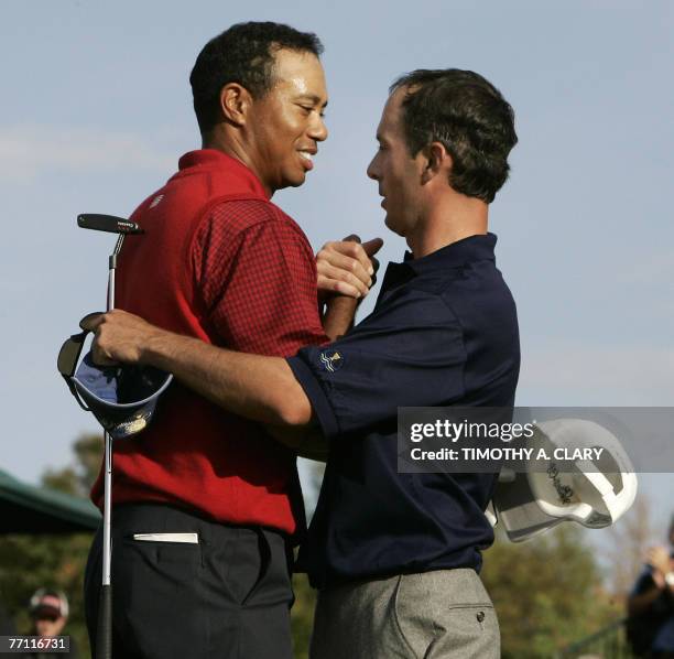 Golfer Tiger Woods hugs International Team player Mike Weir of Canada on the 18th hole after Woods lost his match during the single matches of the...