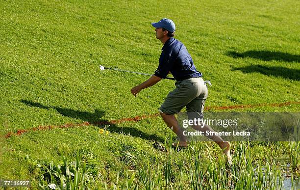 Mike Weir of the International Team runs out of the water after hitting his shot on the 15th hole during the final day singles matches at The...