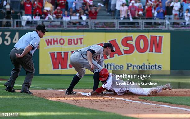 Jimmy Rollins of the Philadelphia Phillies dives under the tag of third baseman Ryan Zimmerman of the Washington Nationals for an RBI triple at...