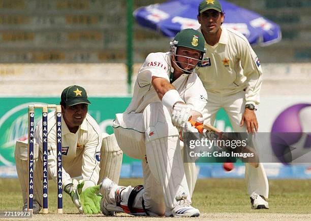 Graeme Smith of South Africa in action while wicket-keeper Kamran Akmal looks on during day one of the first test match between Pakistan and South...