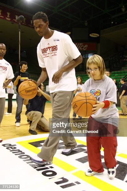 Chris Bosh of the Toronto Raptors works with a Special Olympics athlete during an NBA Cares clinic as part of the 2007 NBA Europe Live Tour at...