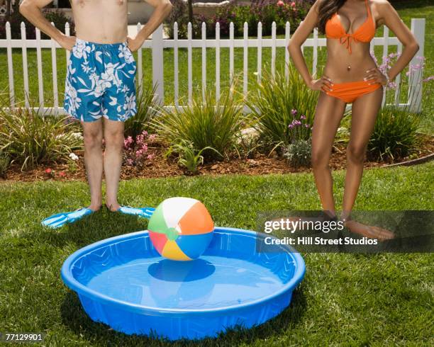 multi-ethnic couple next to kiddie pool - paddling pool stock pictures, royalty-free photos & images