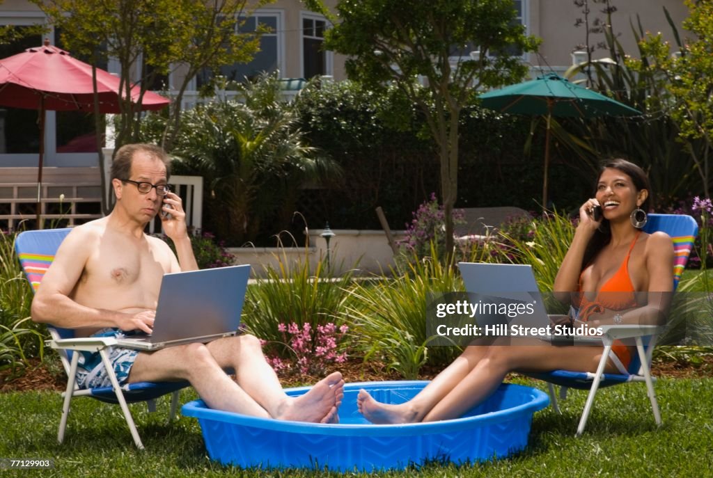 Multi-ethnic couple with feet in kiddie pool