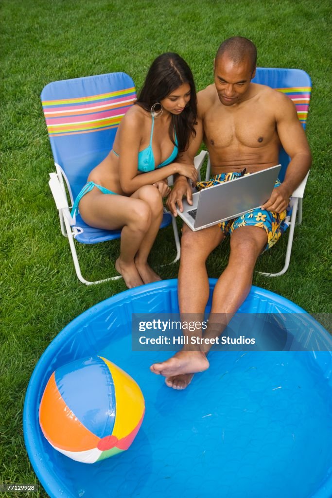 Multi-ethnic couple looking at laptop