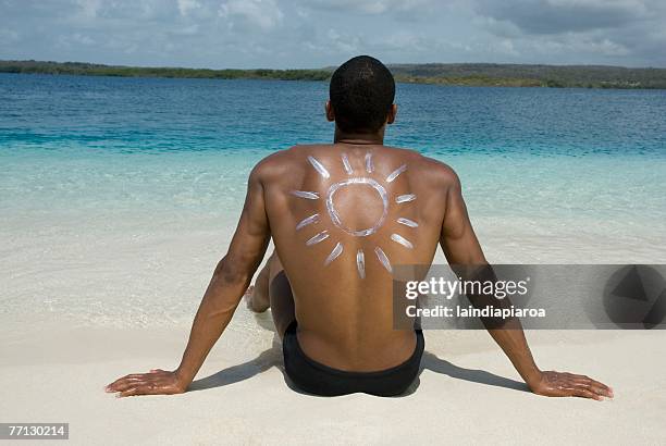 hispanic man sitting on beach - african american man day dreaming stock pictures, royalty-free photos & images