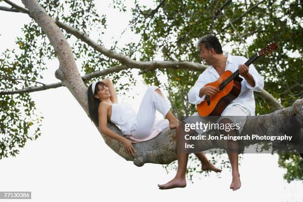 south american man playing guitar for wife - serenading stock pictures, royalty-free photos & images