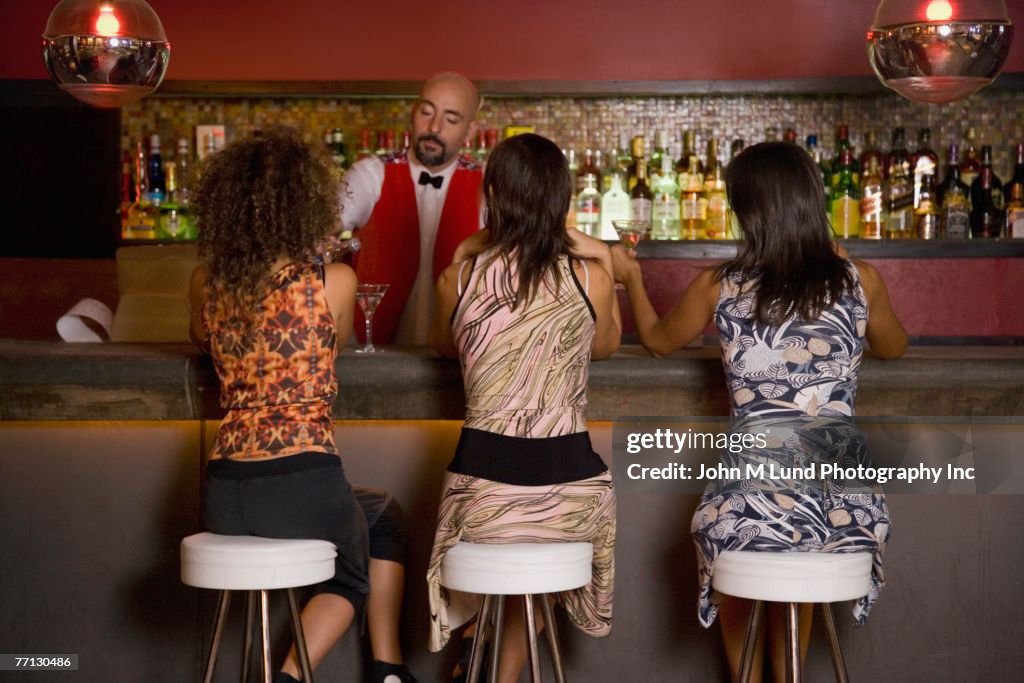 Hispanic women sitting at bar